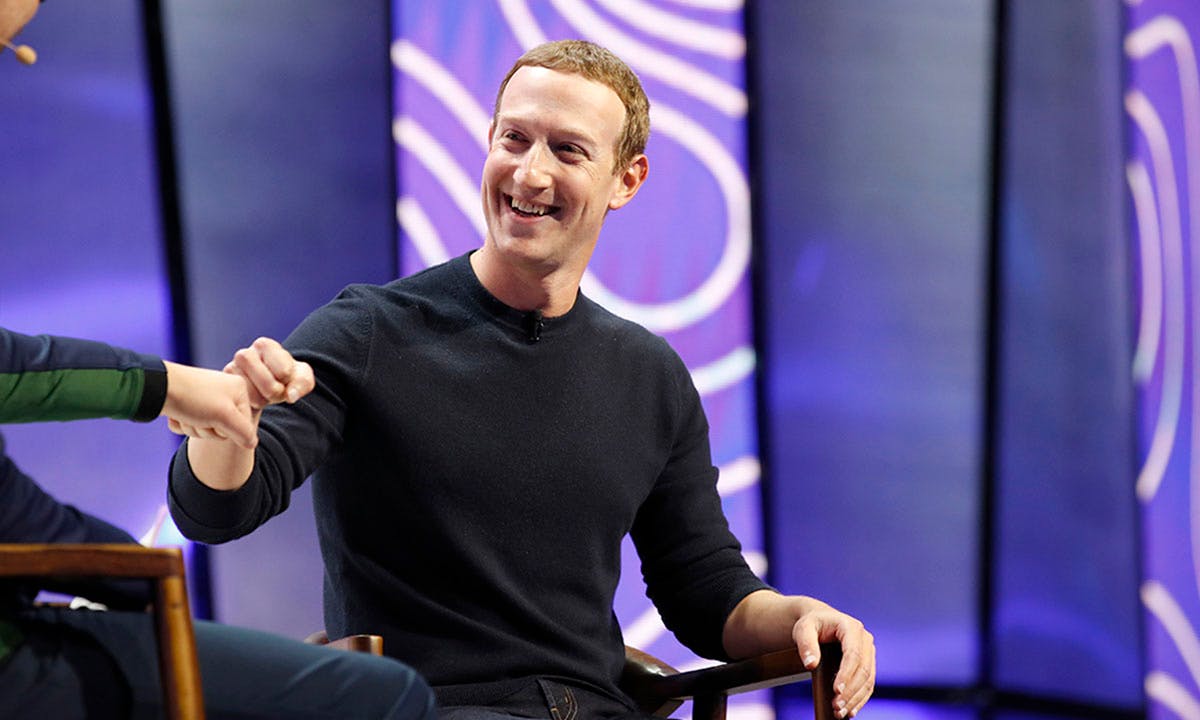 Mark Zuckerberg, chief executive officer and founder of Facebook Inc., fist bumps the moderator during the Silicon Slopes Tech Summit