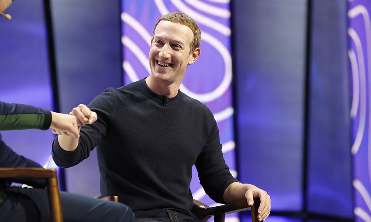 Mark Zuckerberg, chief executive officer and founder of Facebook Inc., fist bumps the moderator during the Silicon Slopes Tech Summit