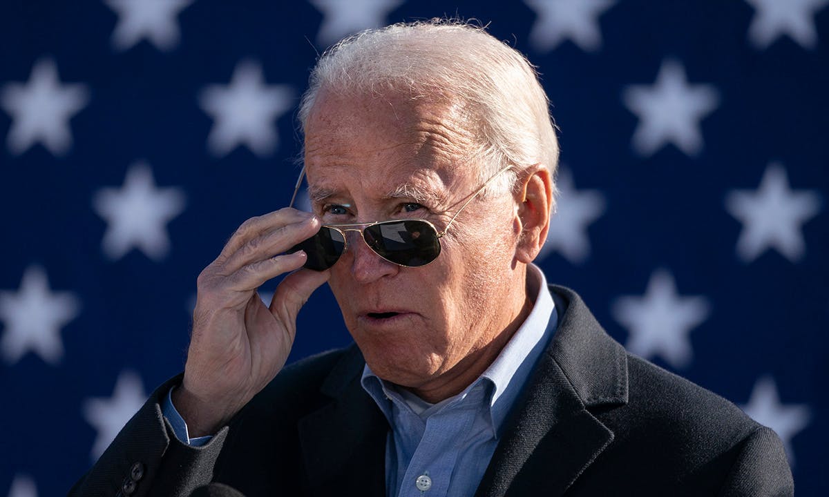 Joe Biden takes off his sunglasses while speaking at a campaign