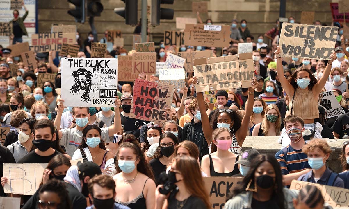 Protesters hold up placards at a gathering in support of the Black Lives Matter