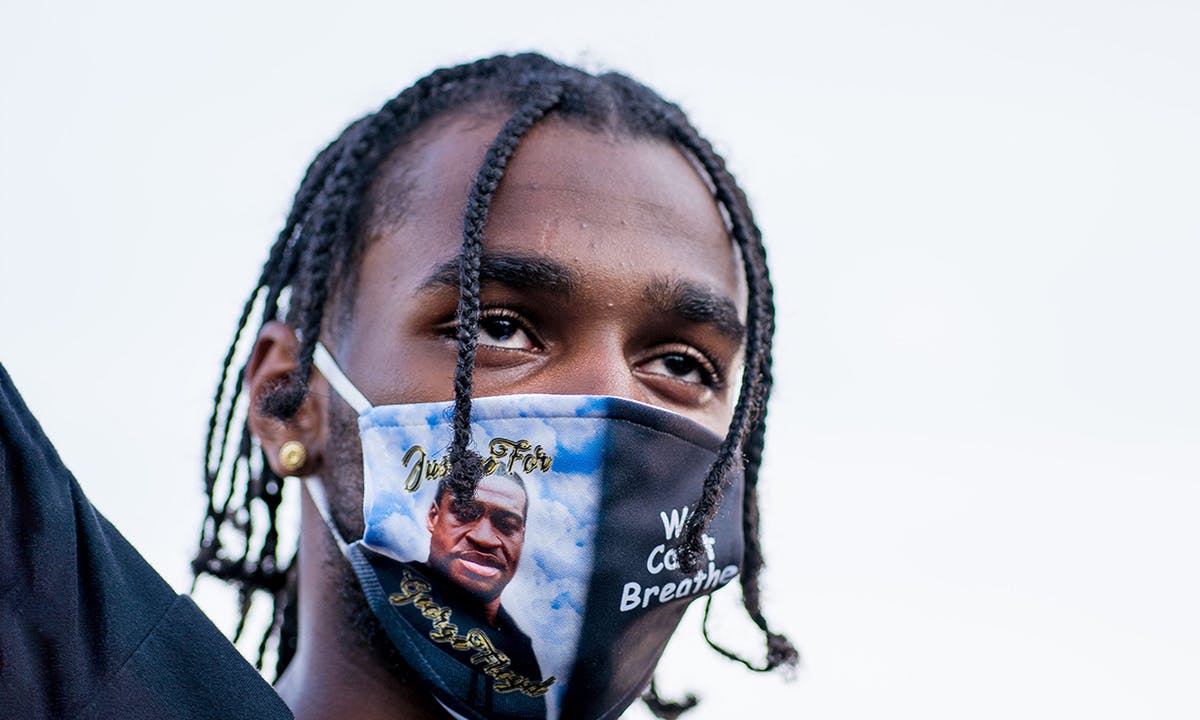 A man raises his hand during a memorial for George Floyd following a day of demonstrations