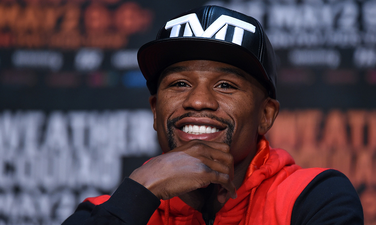 Floyd Mayweather Jr. wearing a TMT hat and smiling