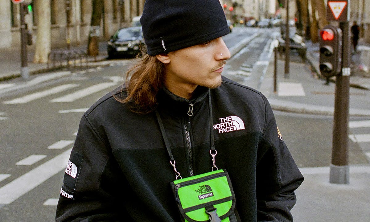 Man Wearing Supreme x The North Face RTG Fleece Jacket in Black With Lime Green Bag