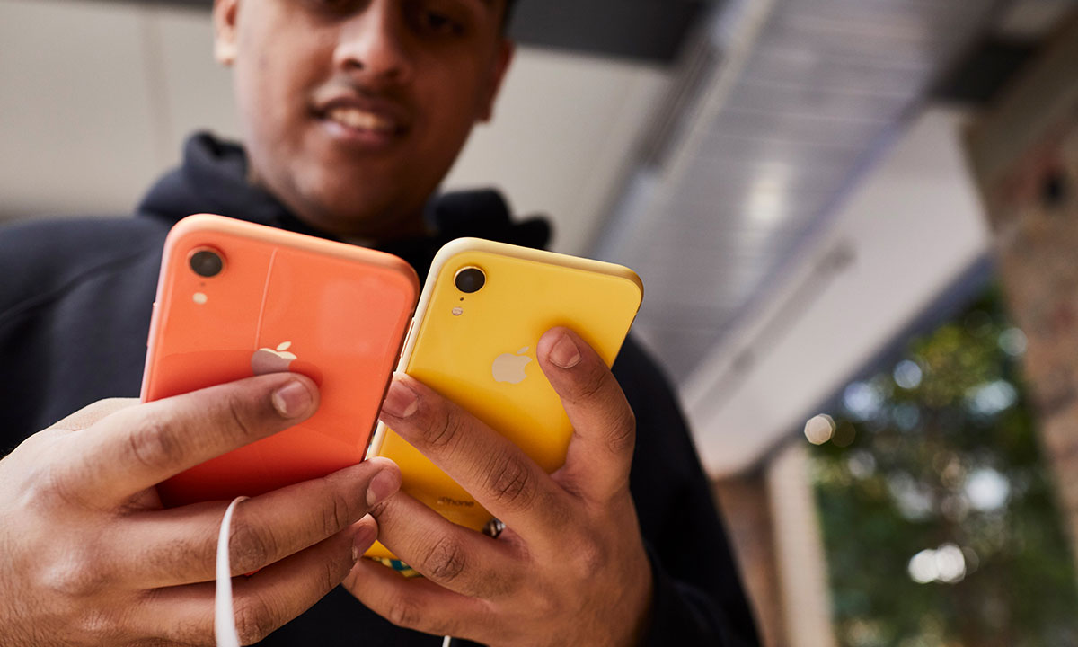 customer holds yellow and orange iPhones in apple store