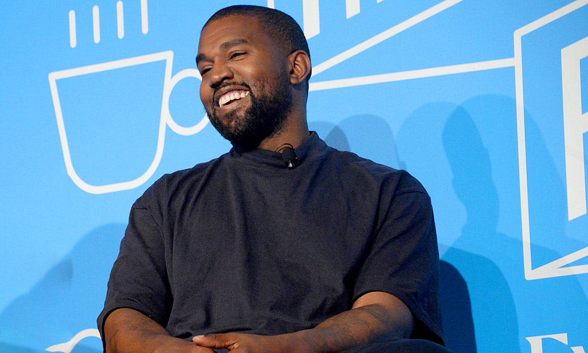 Kanye West smiling blue background