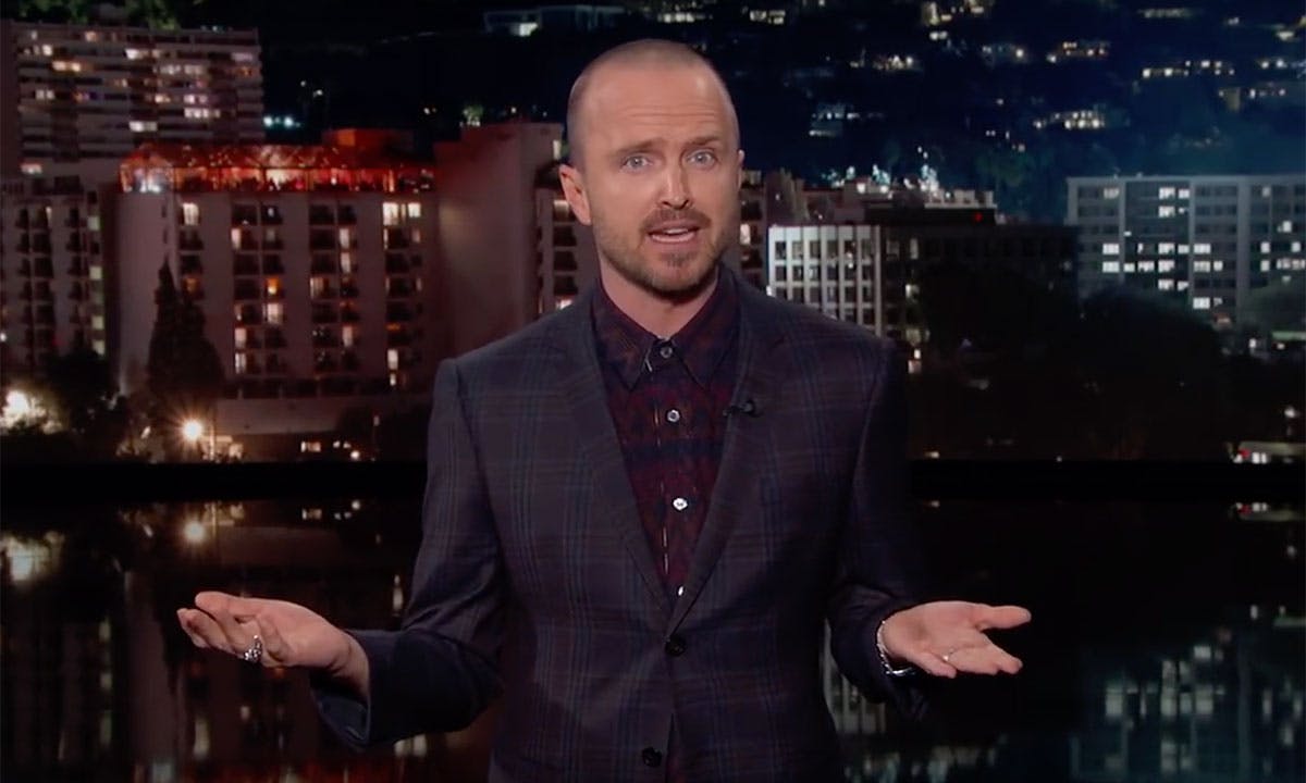 Aaron Paul suit city lights background