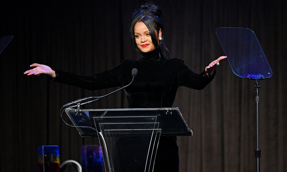 Rihanna speaks on stage black turtleneck gown
