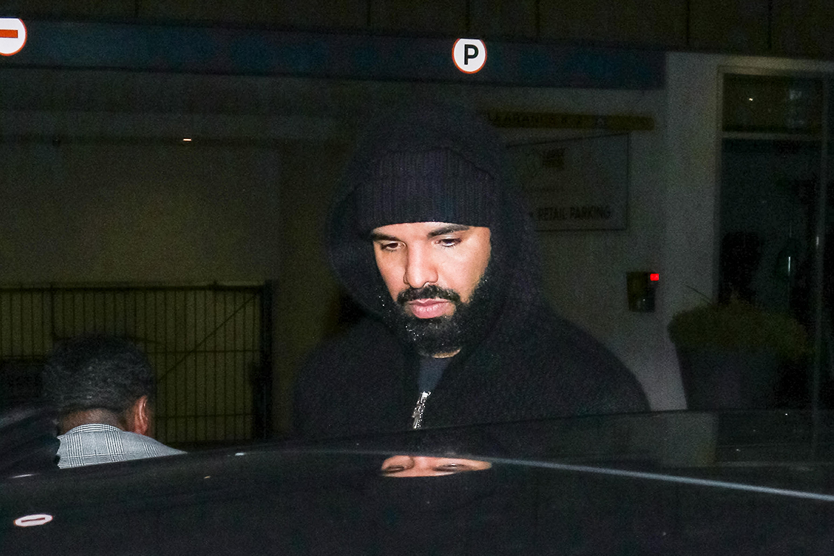 Drake seen stepping into a car with hoodie up