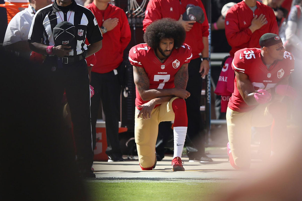 Colin Kaepernick kneels on football field during national anthem