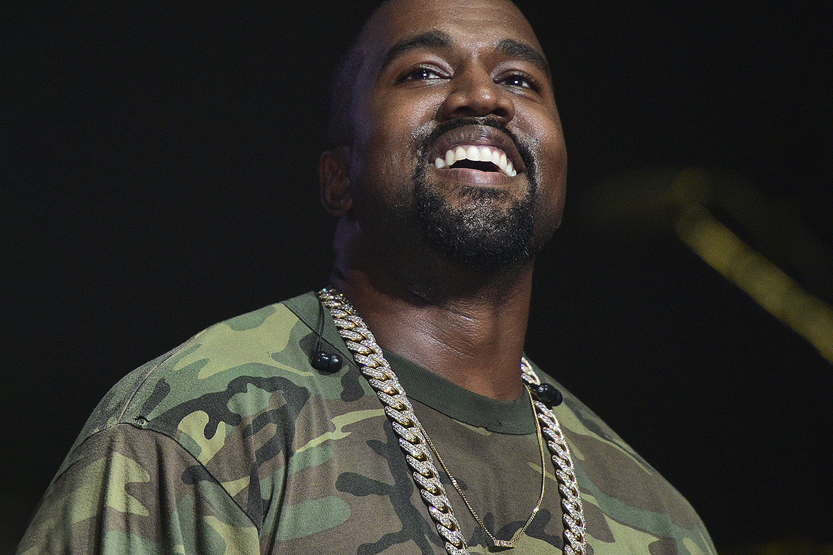 Happy Kanye West wearing diamond necklace