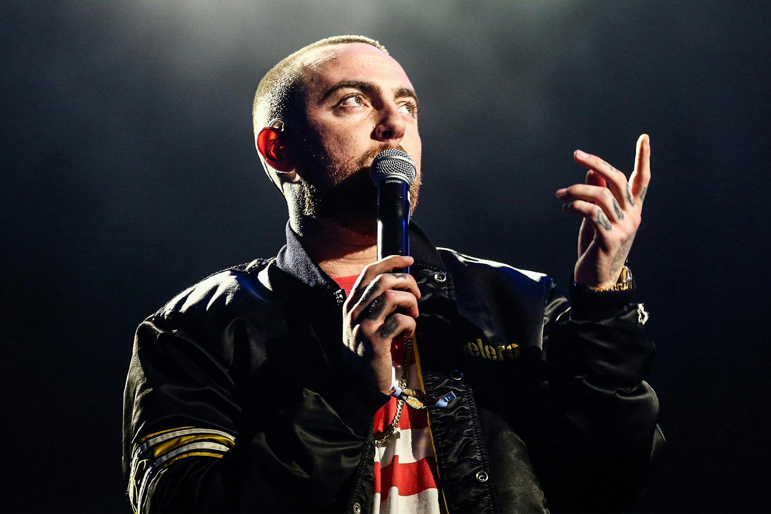 Mac miller performing microphone black jacket