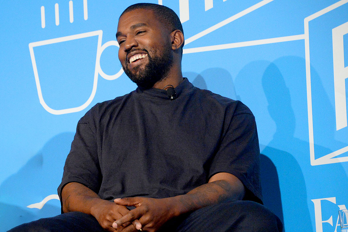 Kanye West smiling blue background