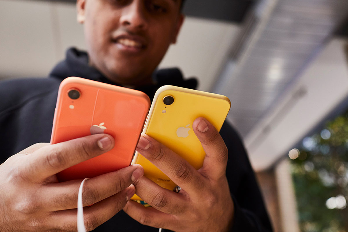 customer holds yellow and orange iPhones in apple store