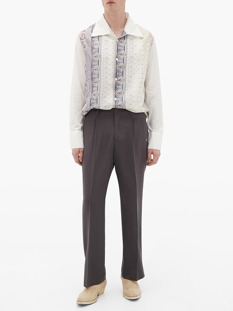 Man wearing white floral Our Legacy shirt, grey formal Our Legacy trousers, and a pair of suede Our Legacy cuban boots
