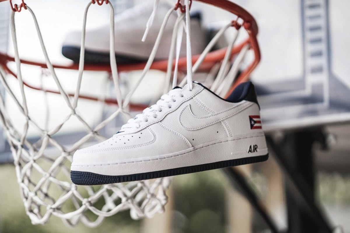 white leather Puerto Rico Nike Air Force 1 hanging in a basketball net