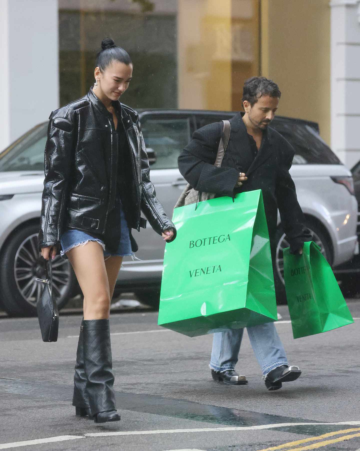 Dua Lipa walking with a large green Bottega Veneta shopping bag