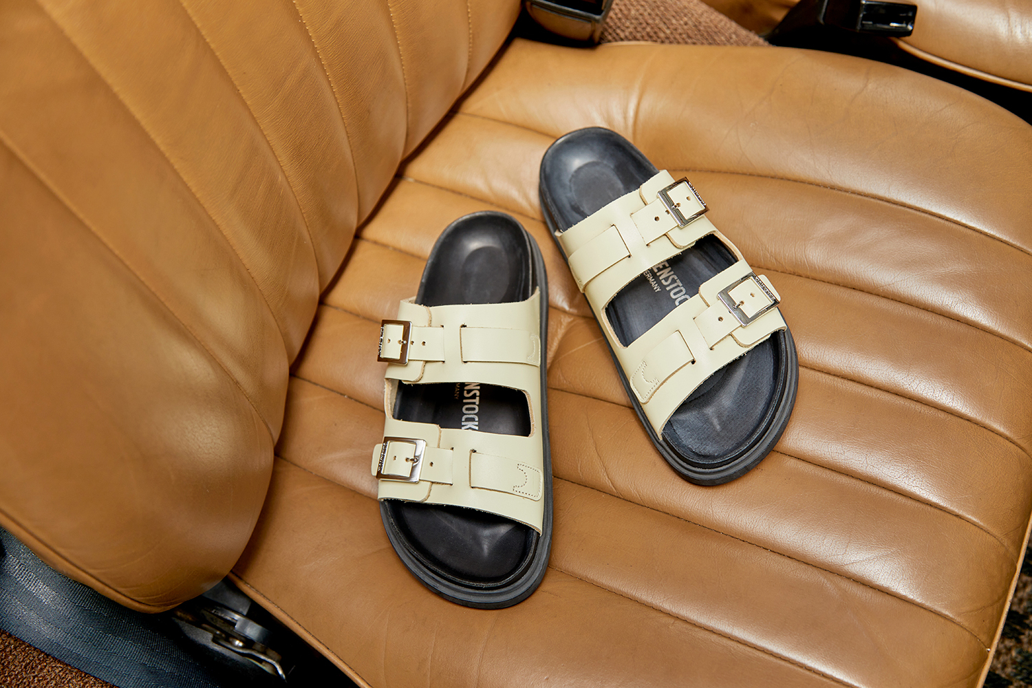 Birkenstock's St. Barths sandal in a white color with two straps, silver buckles, and a black footbed