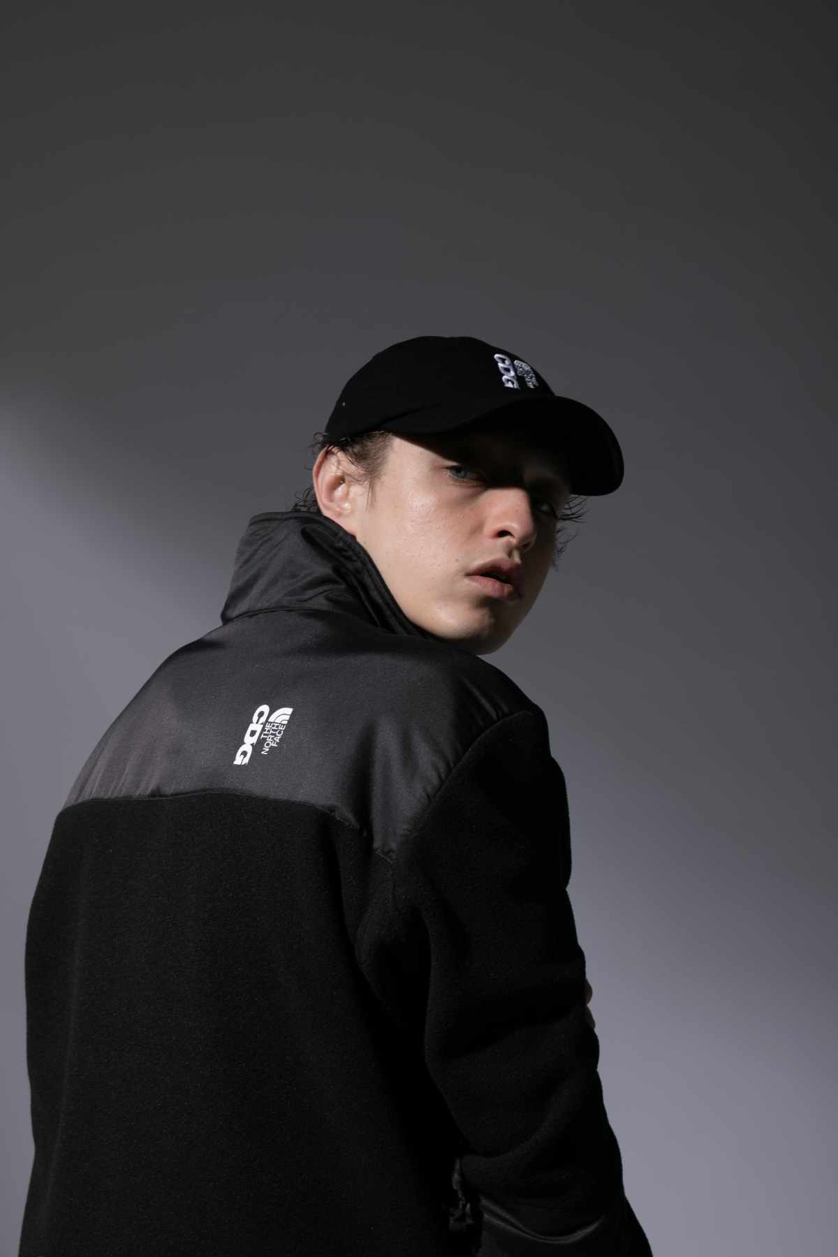A model wears the CDG x The North Face black jacket collaboration