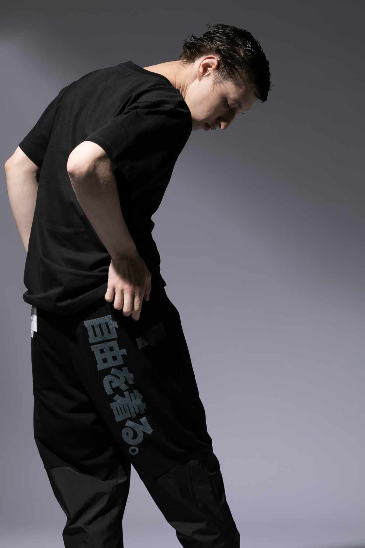 A male model wears the CDG x The North Face collaborative black T-shirt and pants