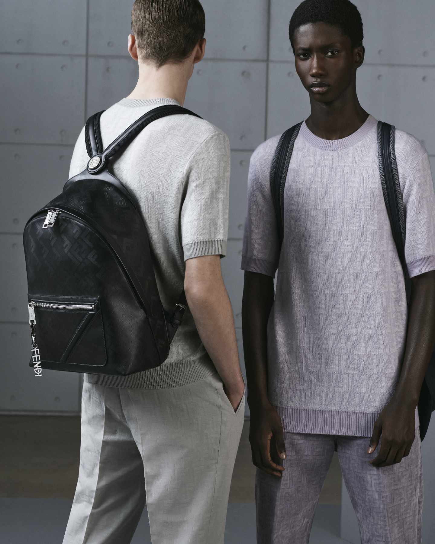 Two models wears Fendi's Chiodo Backpack in black monogrammed leather