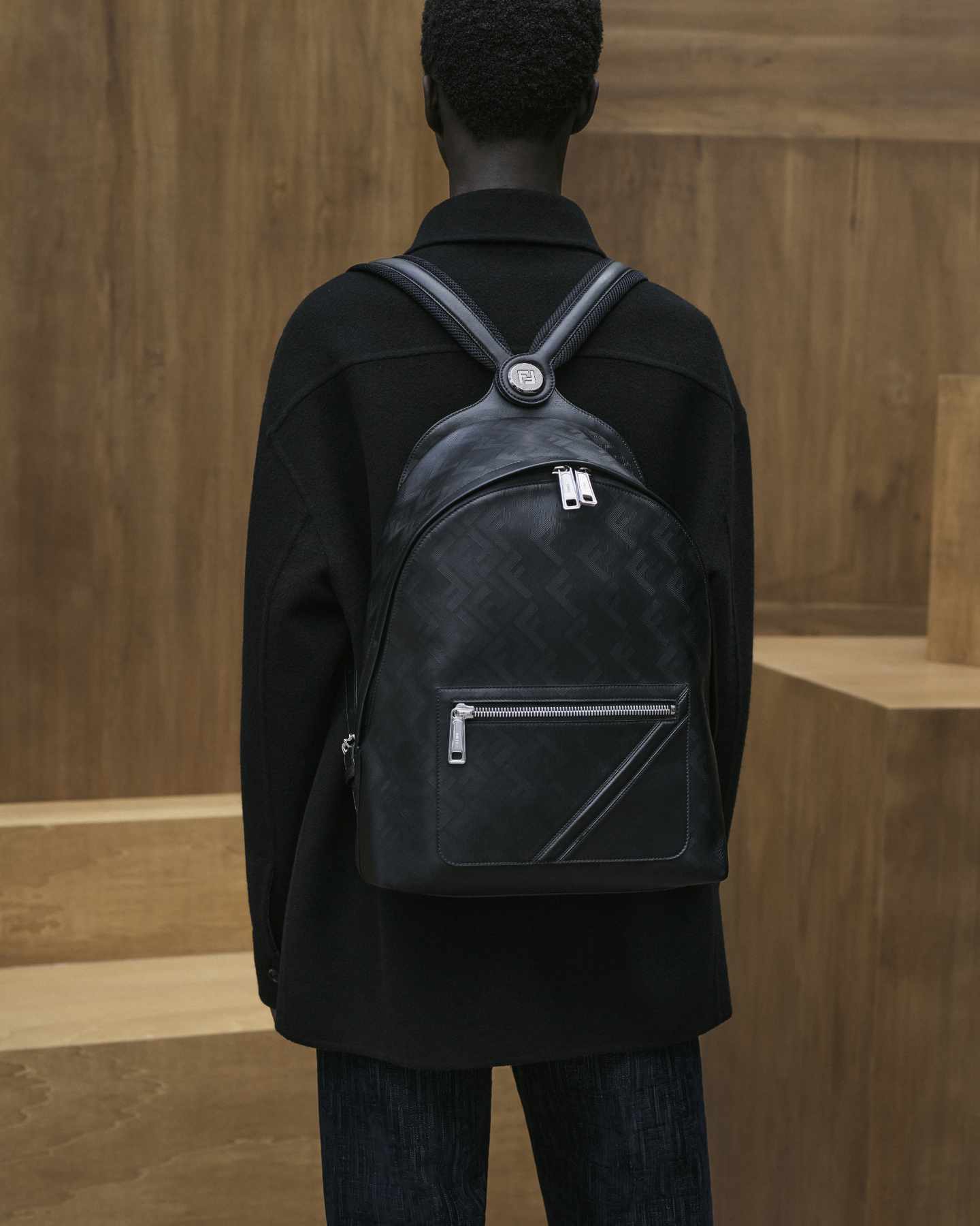 A model wears Fendi's Chiodo Backpack in black leather monogram