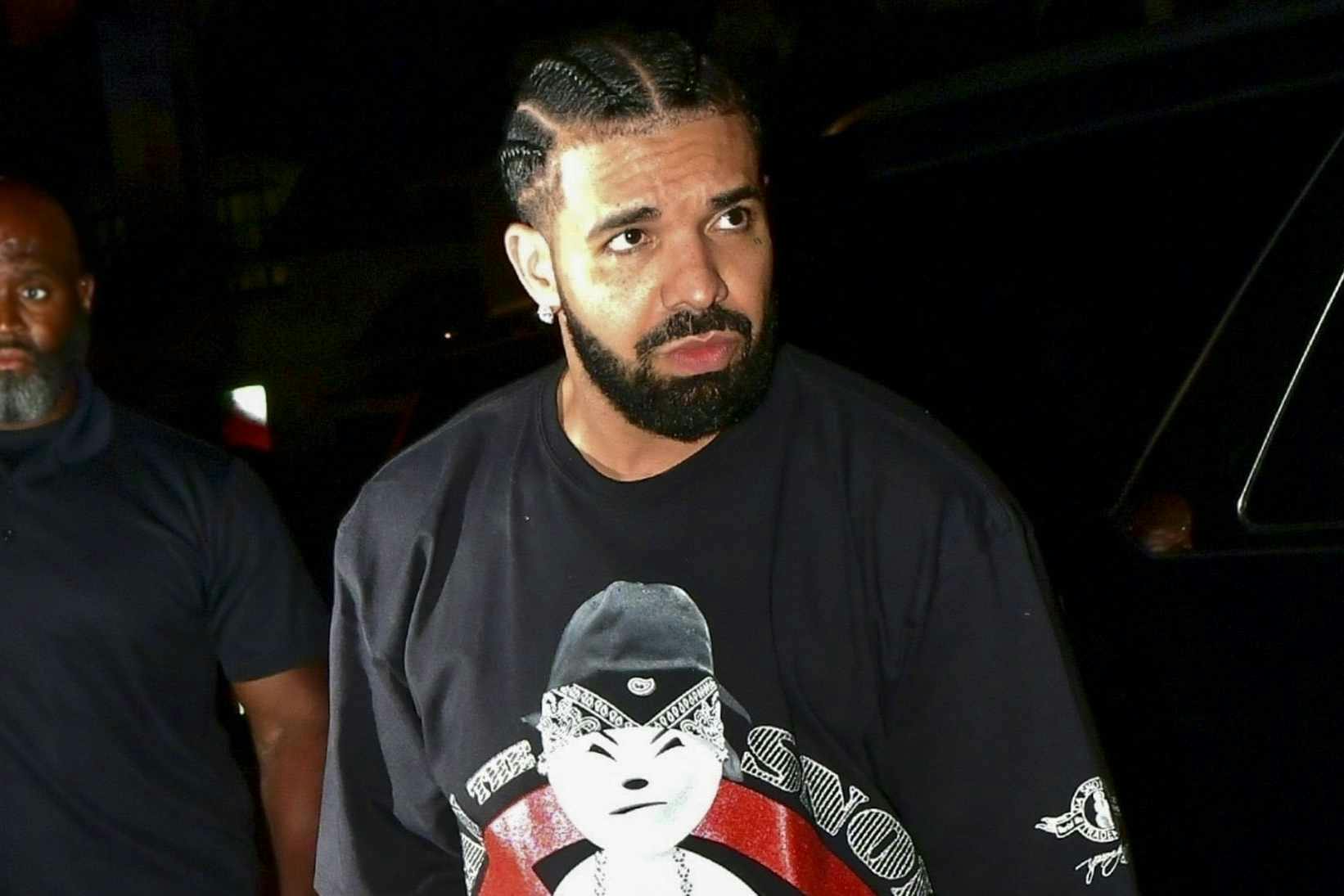 Drake wears snowman T-shirt, leather cargo pants & white platform shoes at night