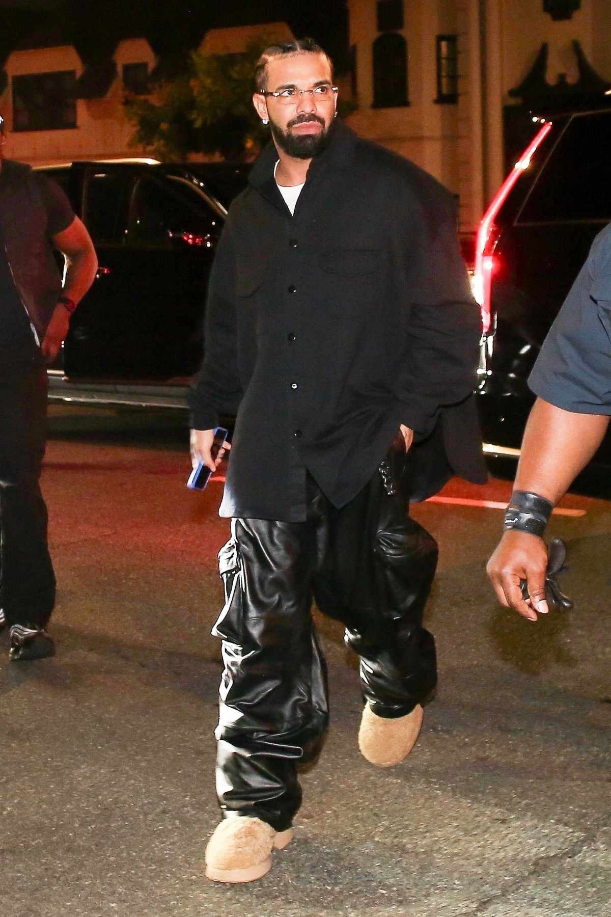 Drake wears snowman T-shirt, leather cargo pants & white platform shoes at night