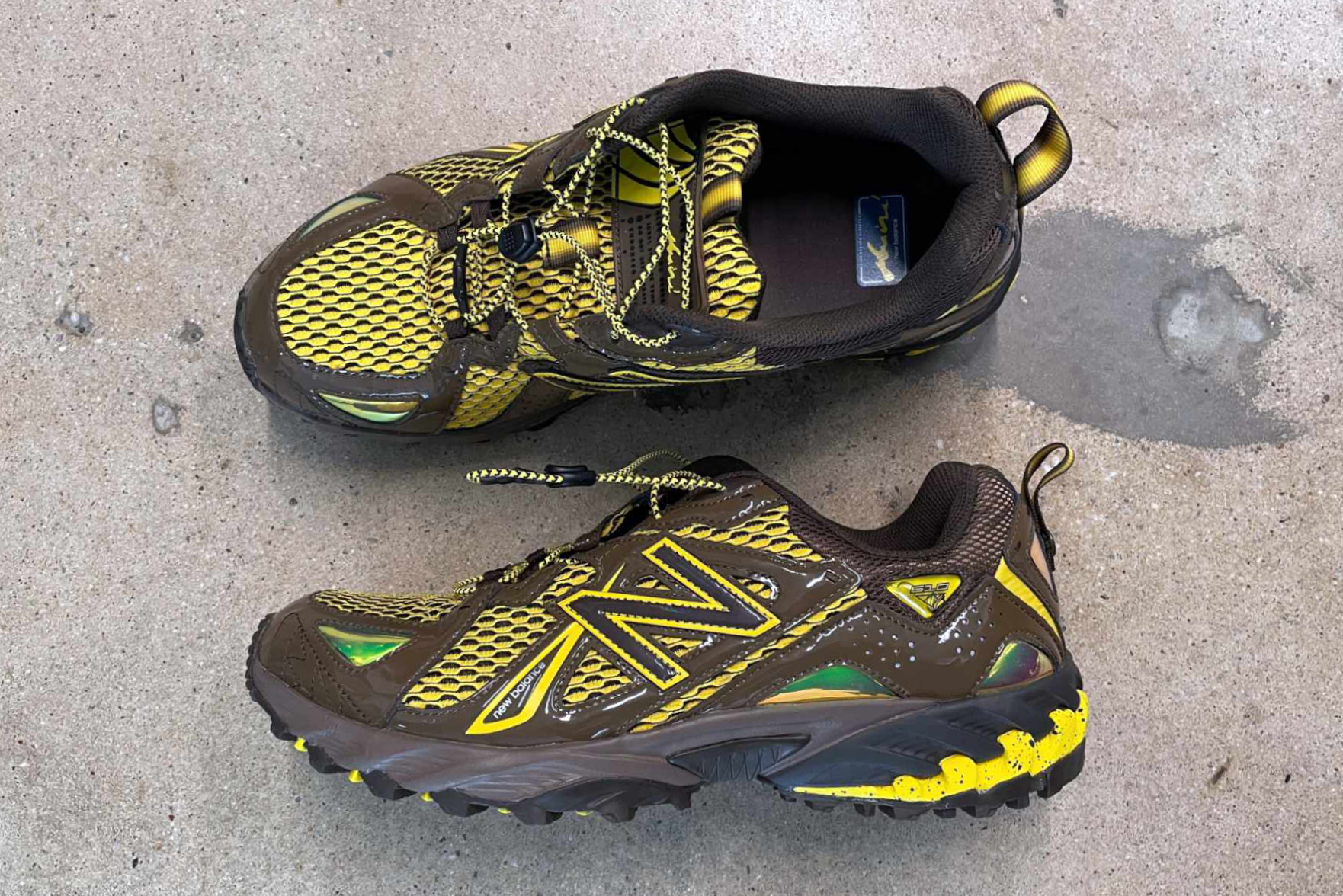 Amine's New Balance 610 shoe, "The Mooz," in brown and yellow colors photographed on the ground