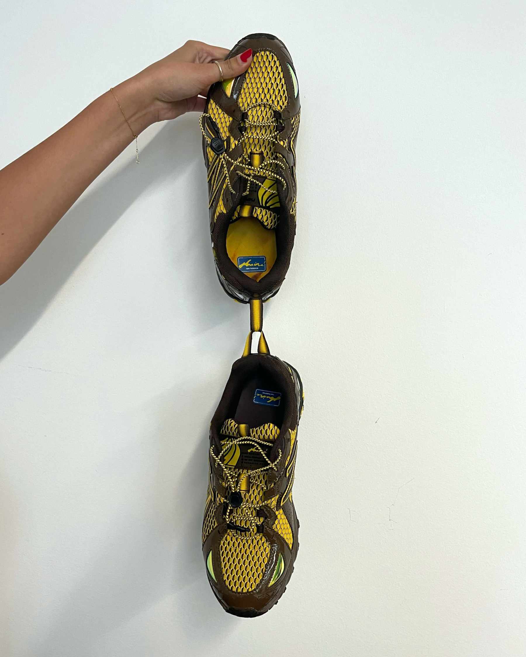 Amine's New Balance 610 shoe, "The Mooz," in brown and yellow colors hanging from the rear pull tab