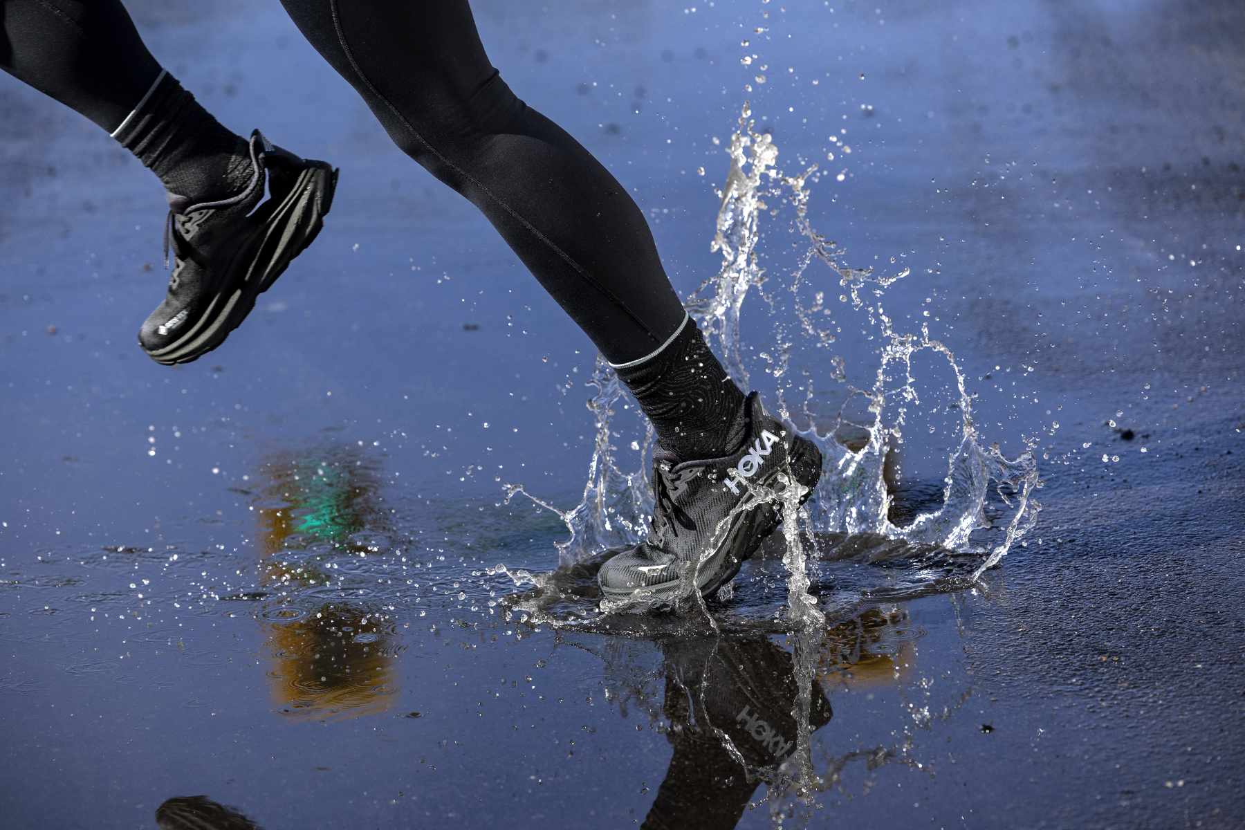 A person running in HOKA's Clifton 9 sneaker in a black GORE-TEX-lined colorway