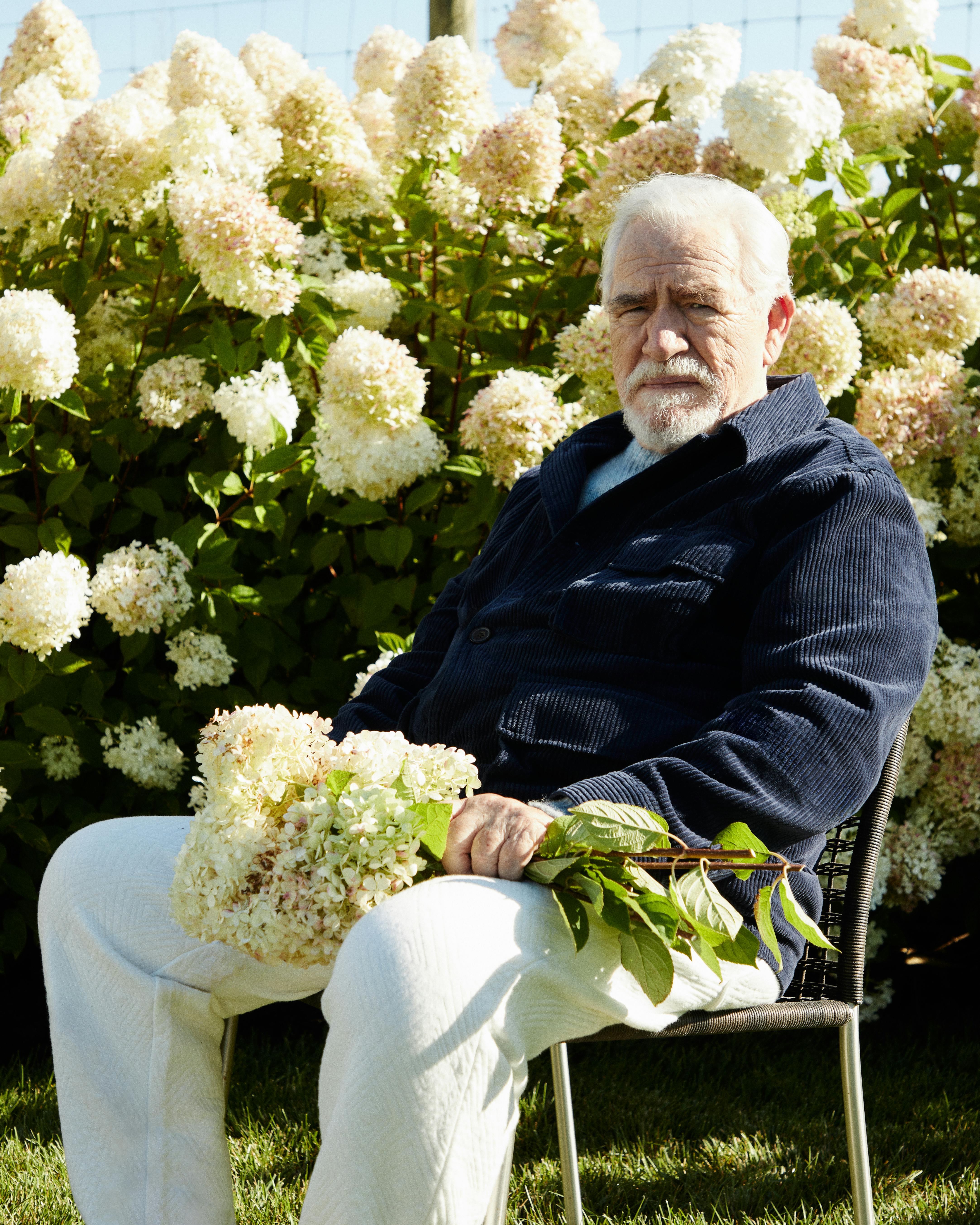 A photograph of Brian Cox, the actor famous for portraying Logan Roy on 'Succession,' wears a KITH shirt in front of a field of flowers