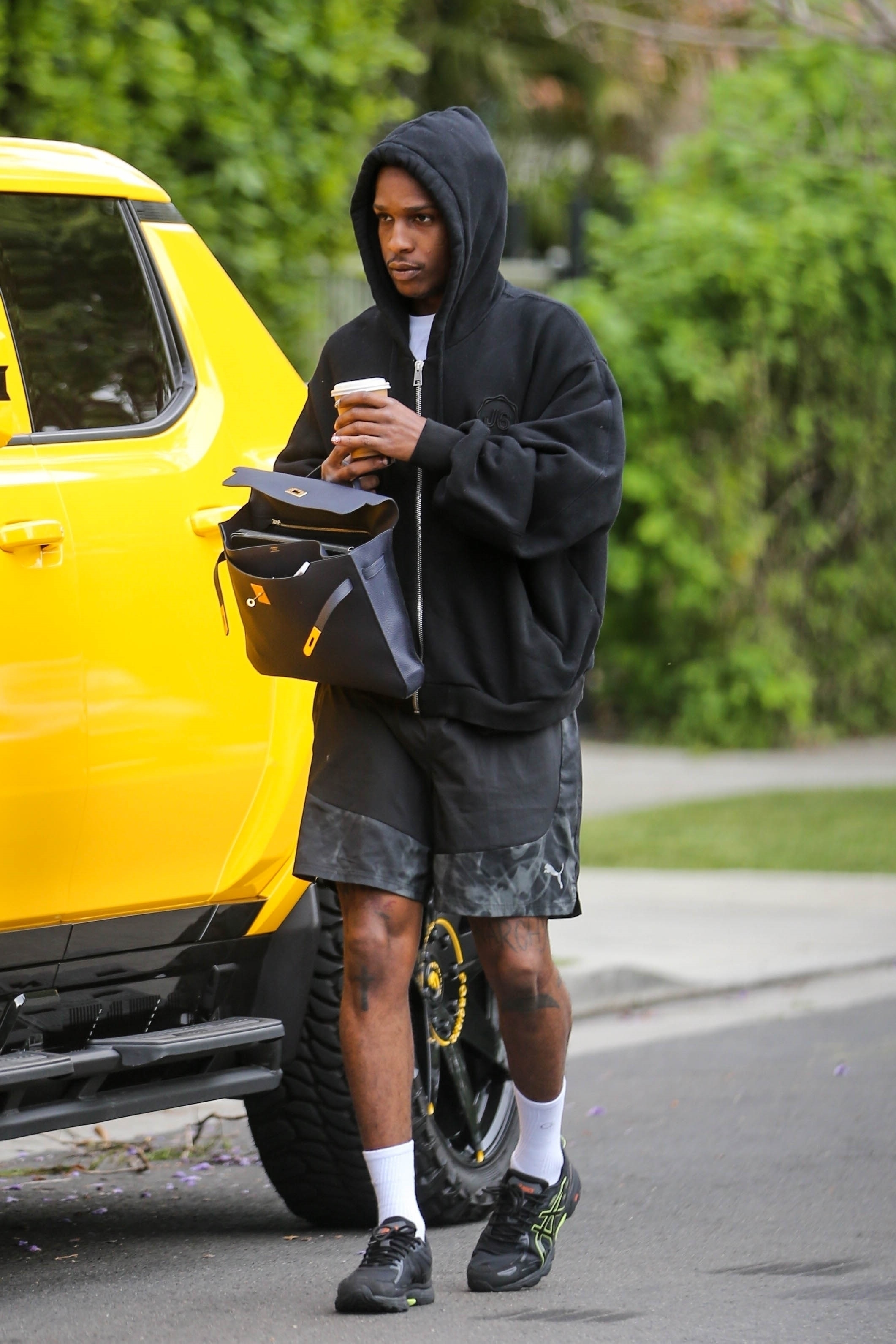 A$AP Rocky seen on August 29 wearing a black hoodie, PUMA shorts & ASICS sneakers with an Hermes Birkin bag