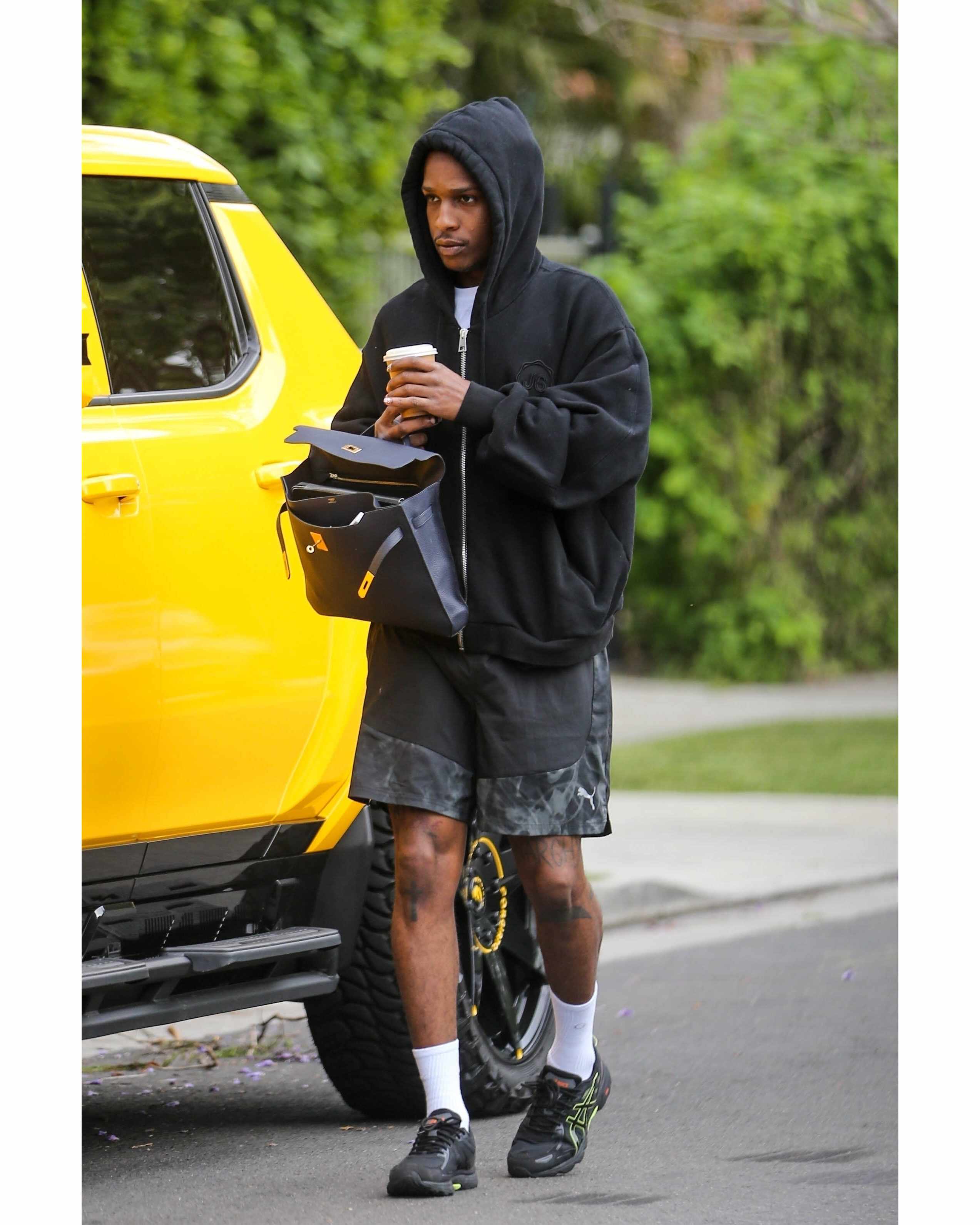A$AP Rocky seen on August 29 wearing a black hoodie, PUMA shorts & ASICS sneakers with an Hermes Birkin bag