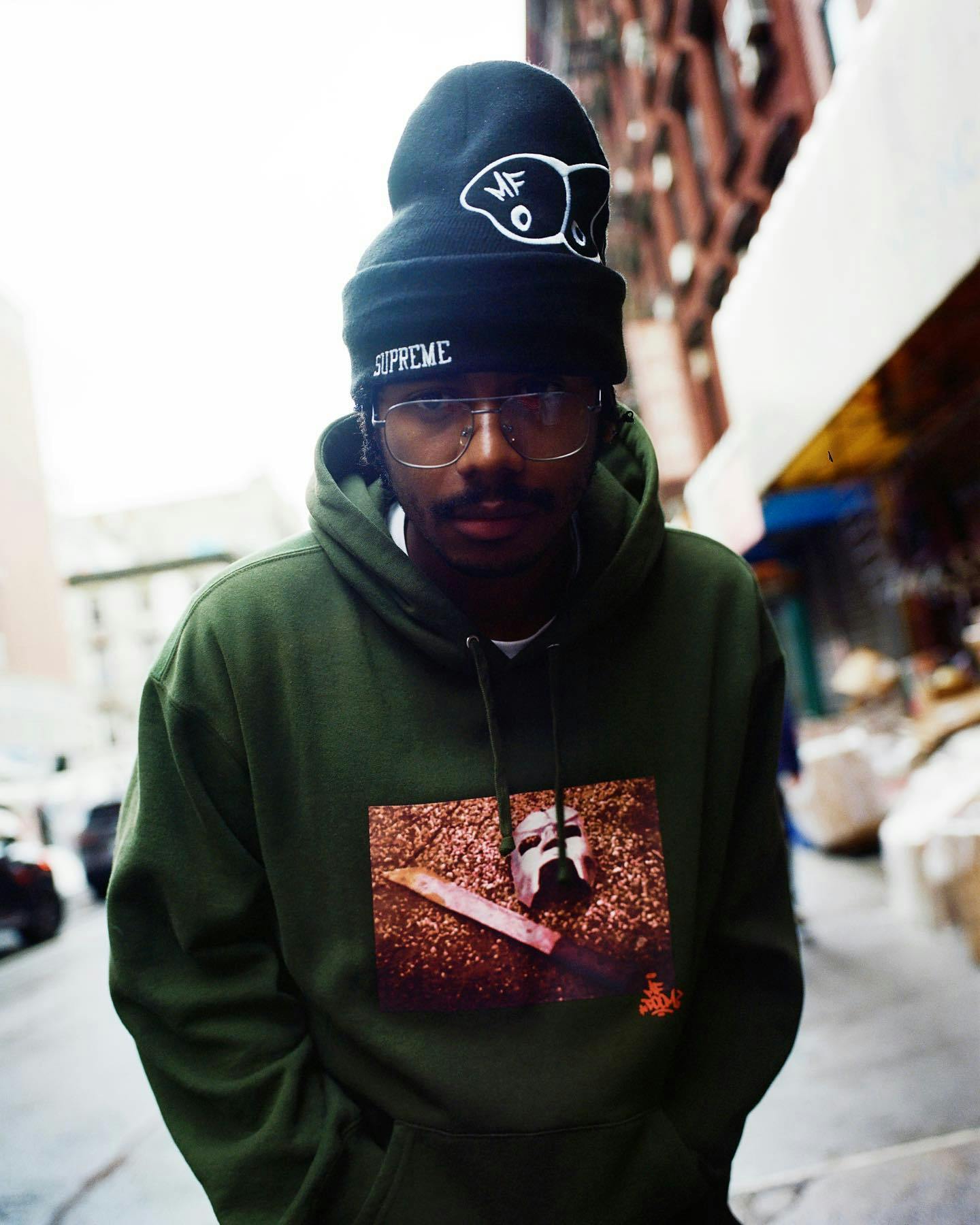 A skater wears Supreme & MF DOOM's collaborative beanie & graphic hoodie