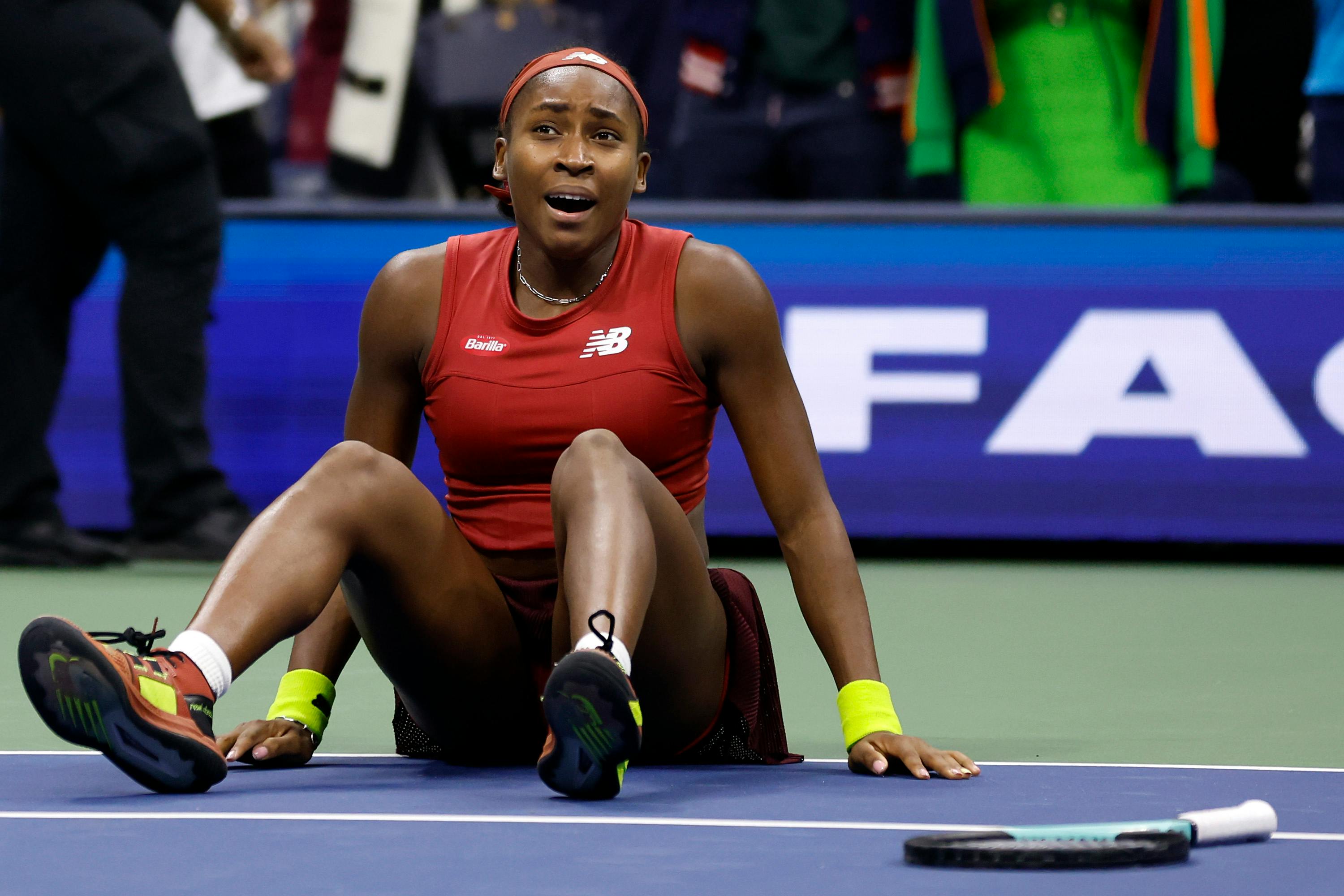 Coco Gauff, wearing a red Barilla & New Balance top, celebrates her victory at the 2023 US Open