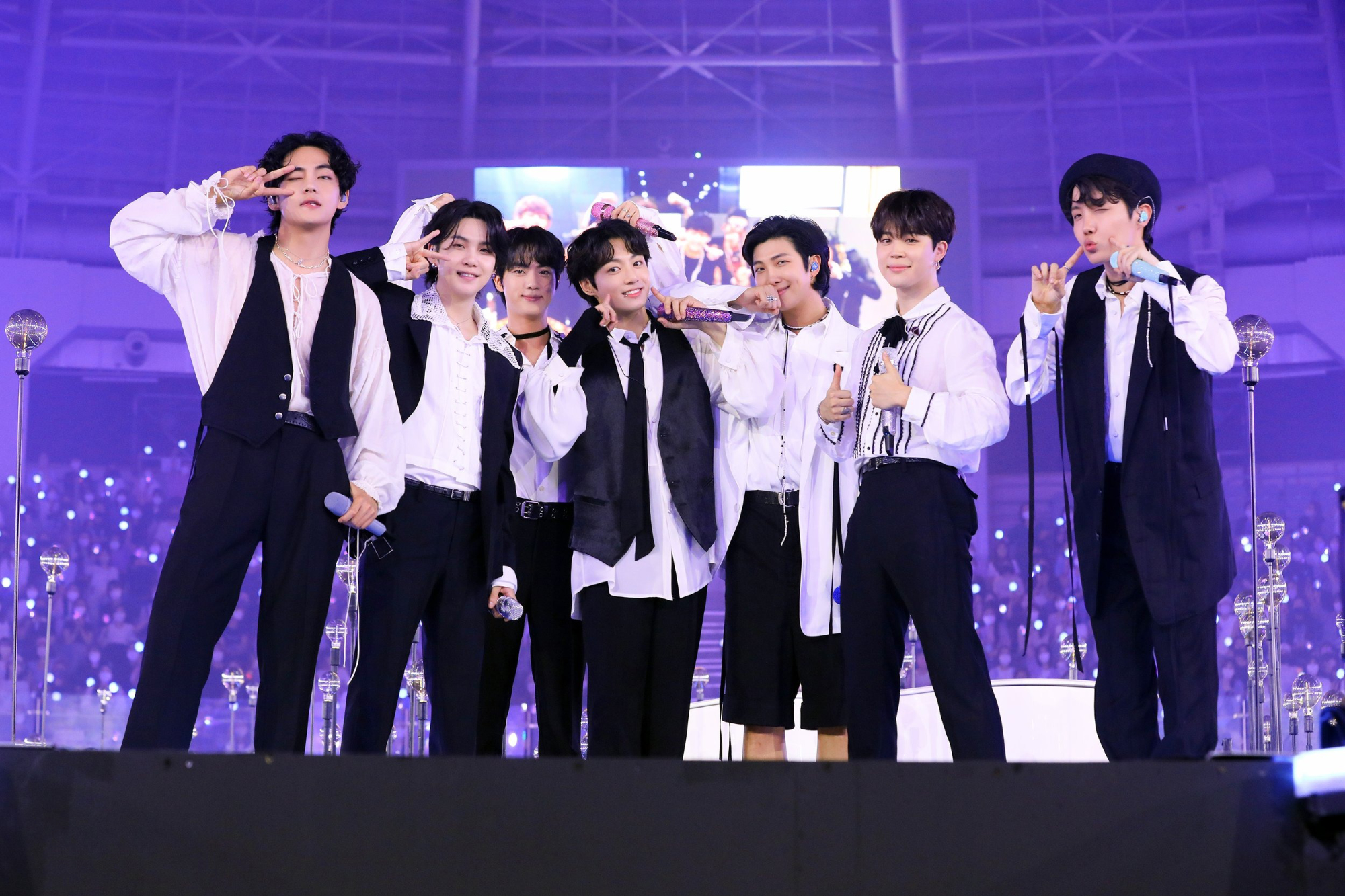 Boy band BTS seen posing on stage, including members RM, Jungkook, Jimin, V, Suga, Jin & J-Hope