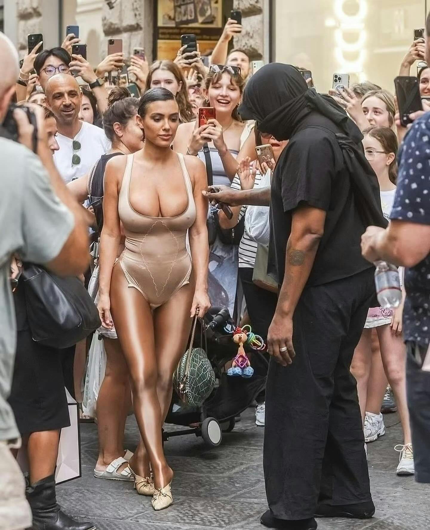 Kanye & wife Bianca Censori seen in Milan, Italy, wearing a black hooded outfit & nude see-through bodysuit