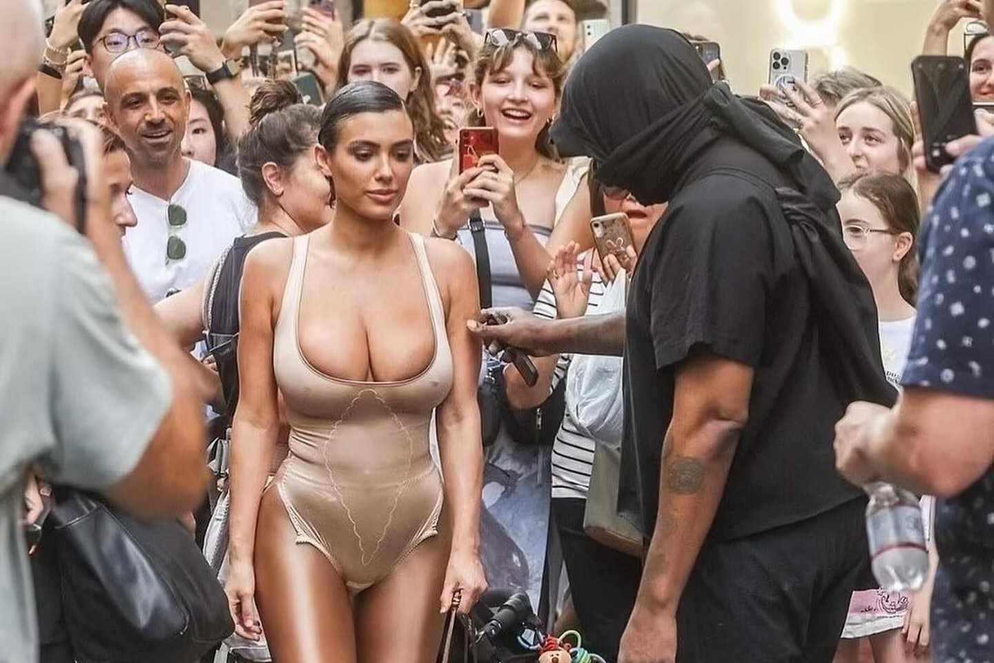 Kanye & wife Bianca Censori seen in Milan, Italy, wearing a black hooded outfit & nude see-through bodysuit