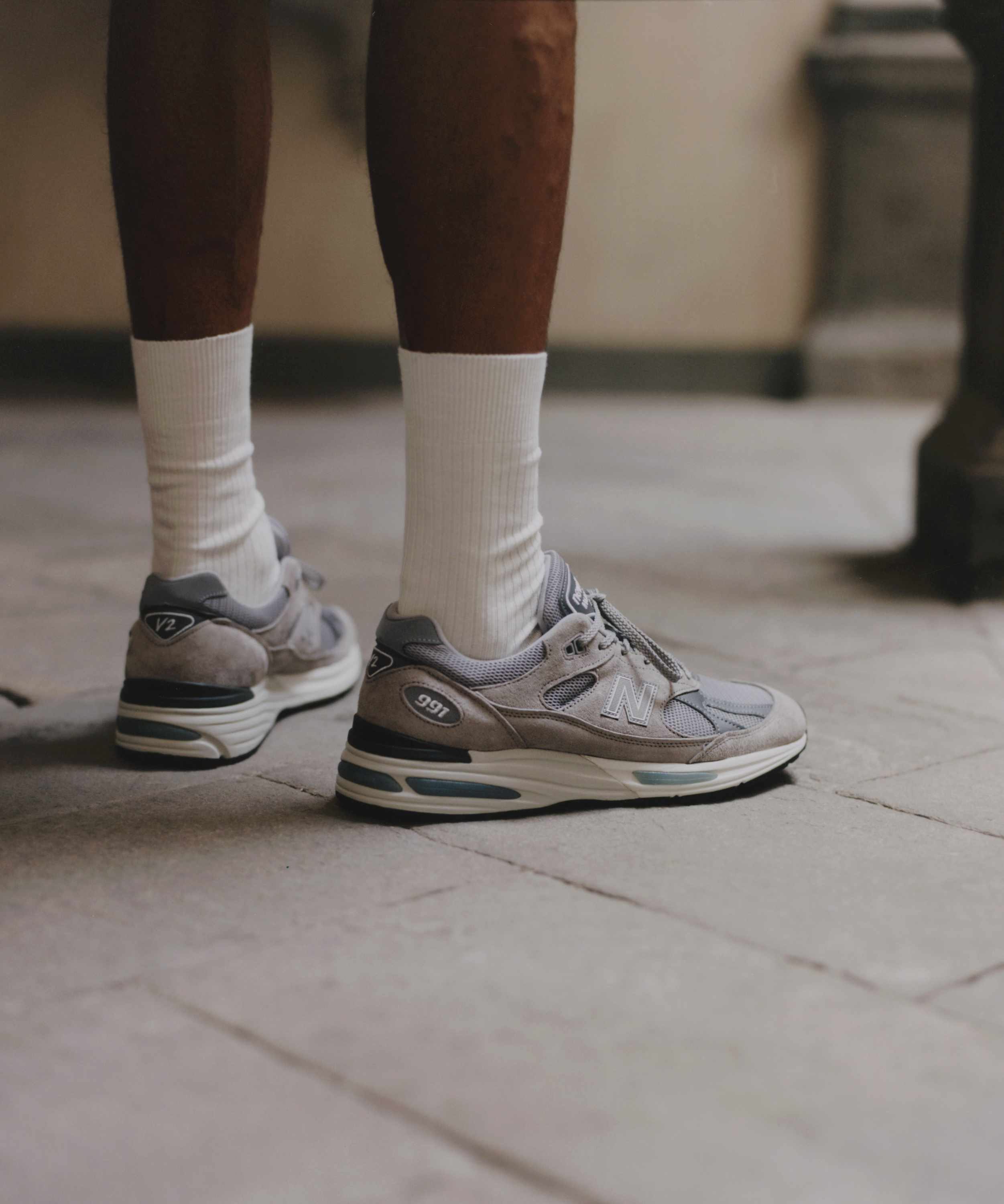 Lifestyle photos showing Italians wearing New Balance's grey suede 991v2 sneaker