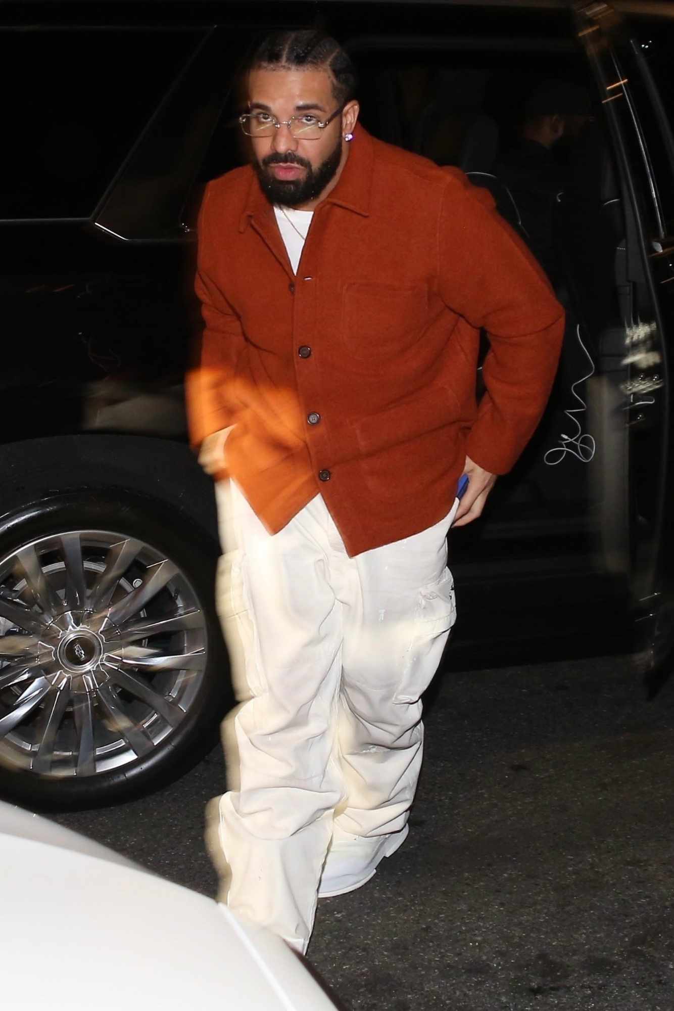 Drake wears a red shirt over white pants with thin-rimmed glasses on a night out in Los Angeles