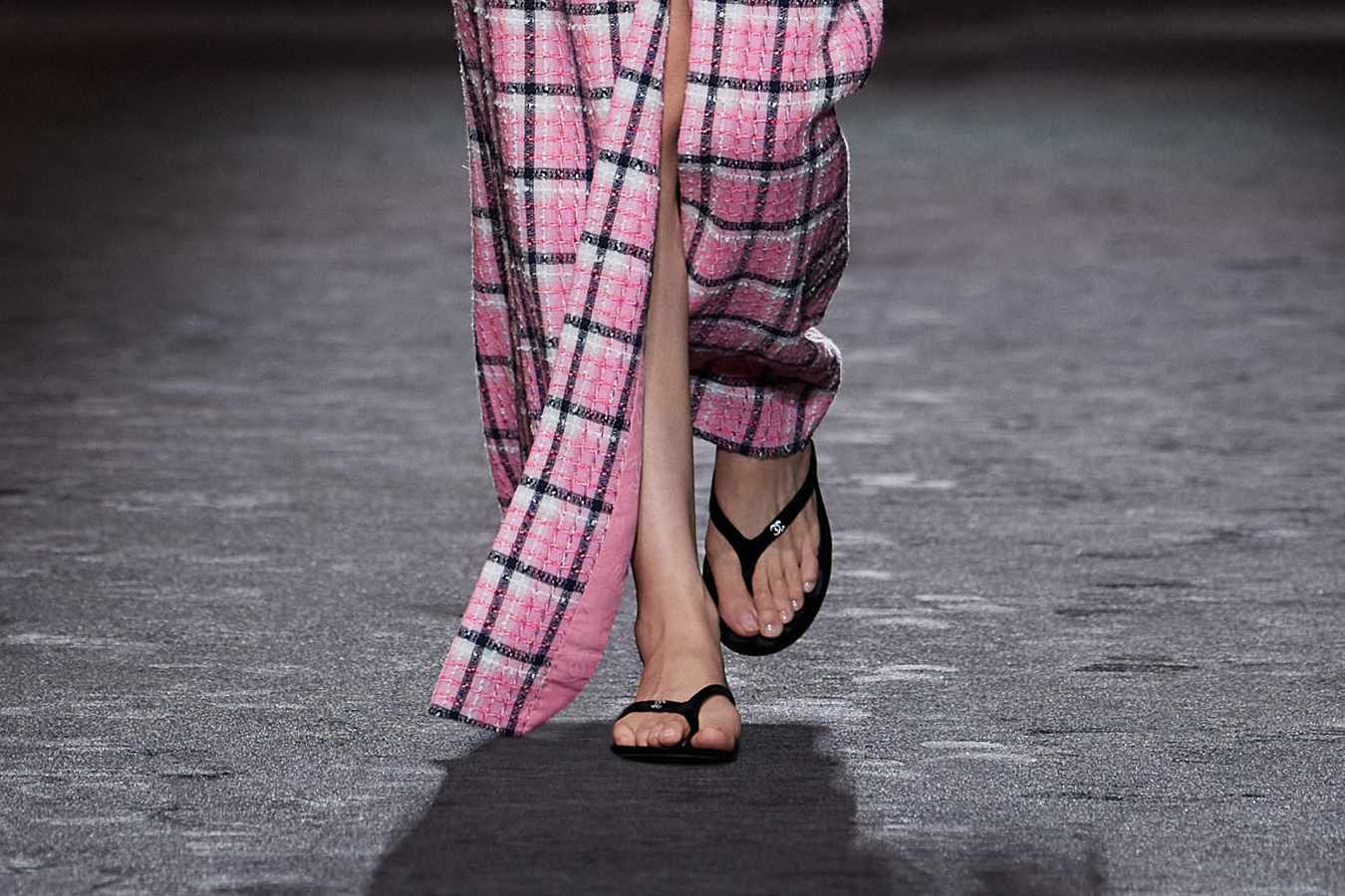 A model wears Chanel flip-flops on the SS24 runway