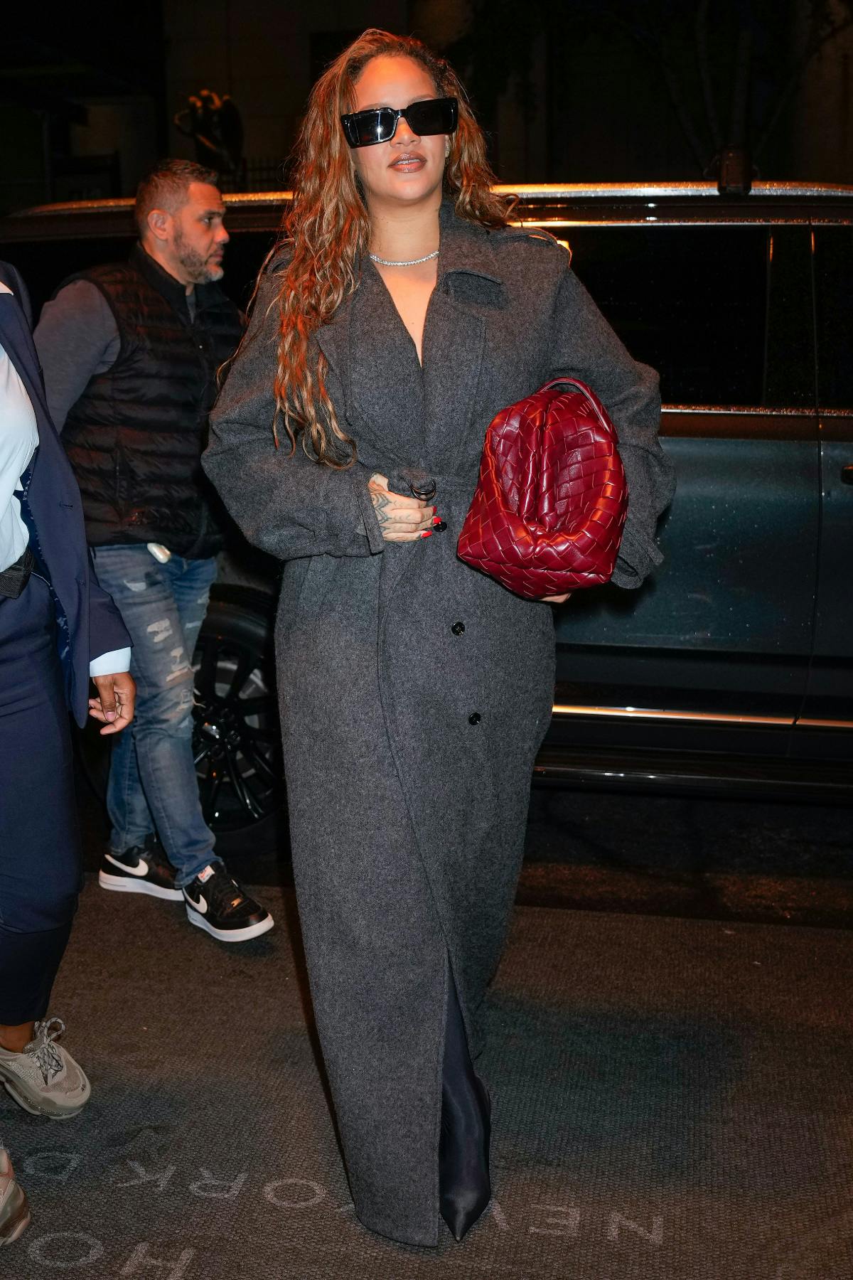 Rihanna wears a Bottega Veneta handbag and grey overcoat