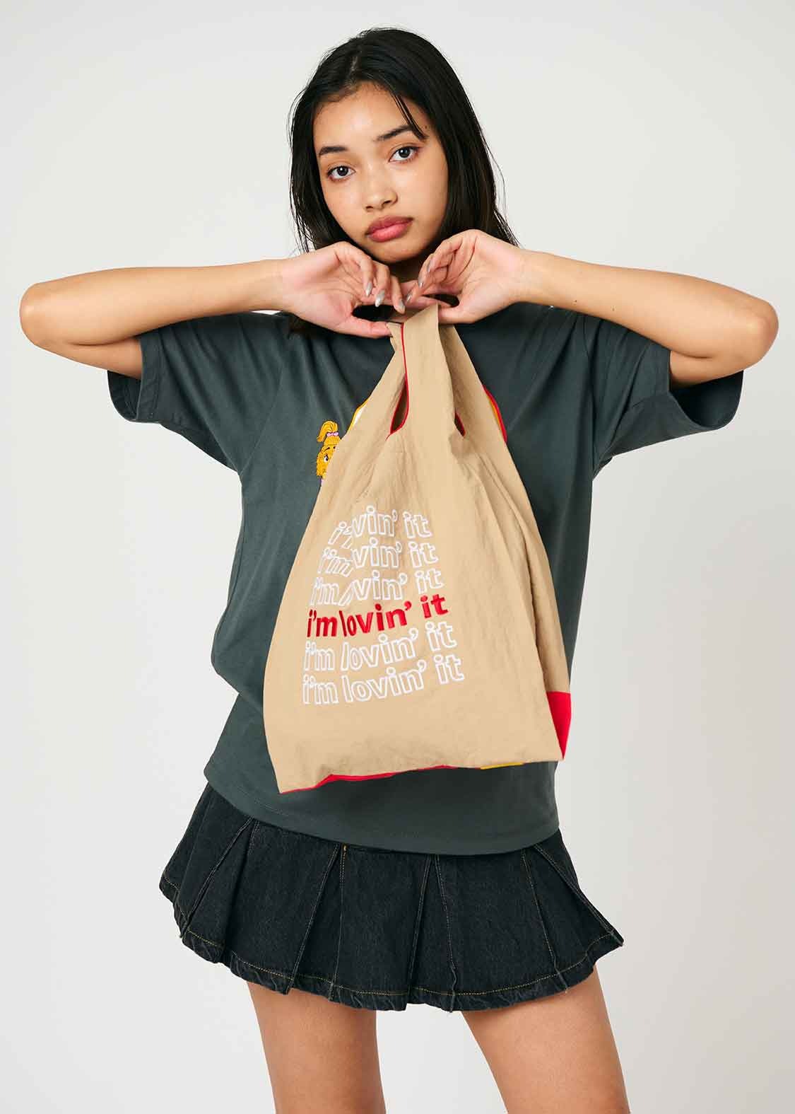 A model wears McDonald's x Graniph collaborative clothing & paper bag