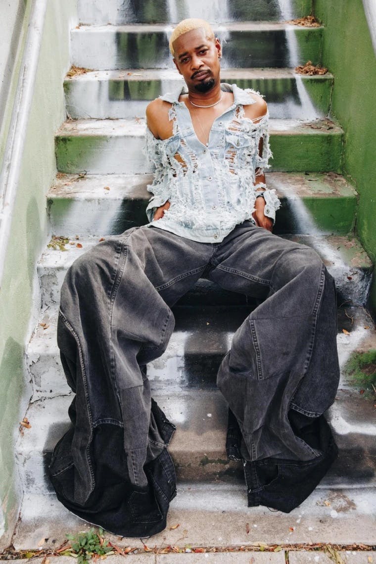 Man sitting on stairs with red Louis Vuitton X Supreme leather