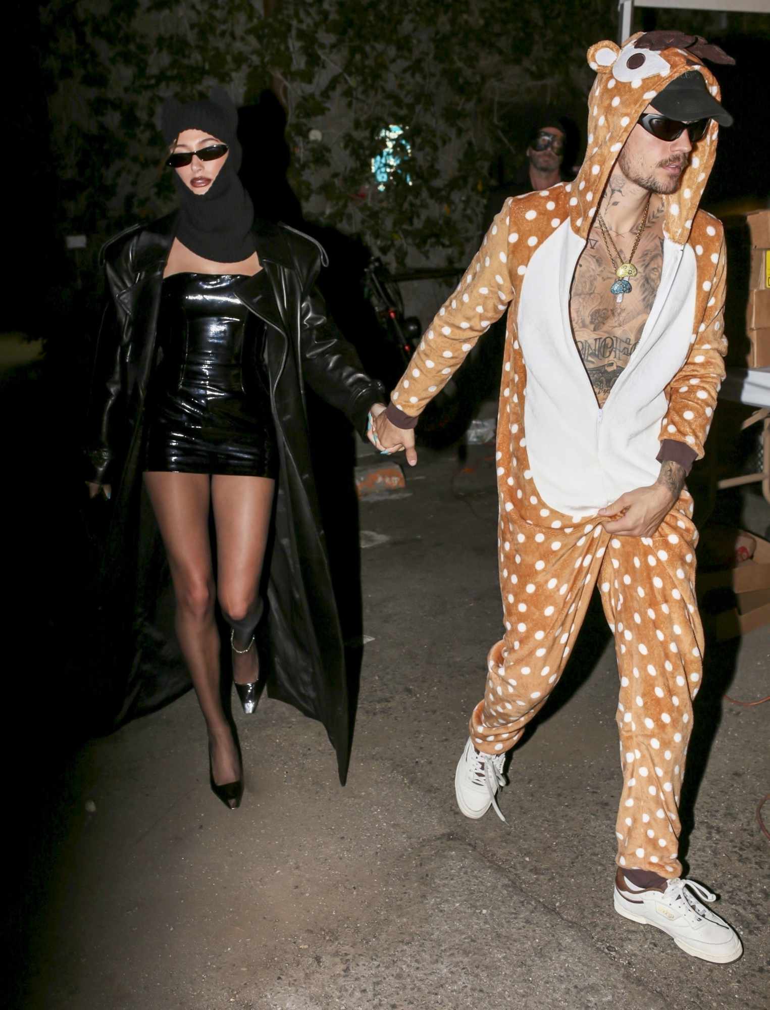Justin & Hailey Bieber wear their 2023 Halloween costumes. Hailey is dressed in leather & Justin has a giraffe costume