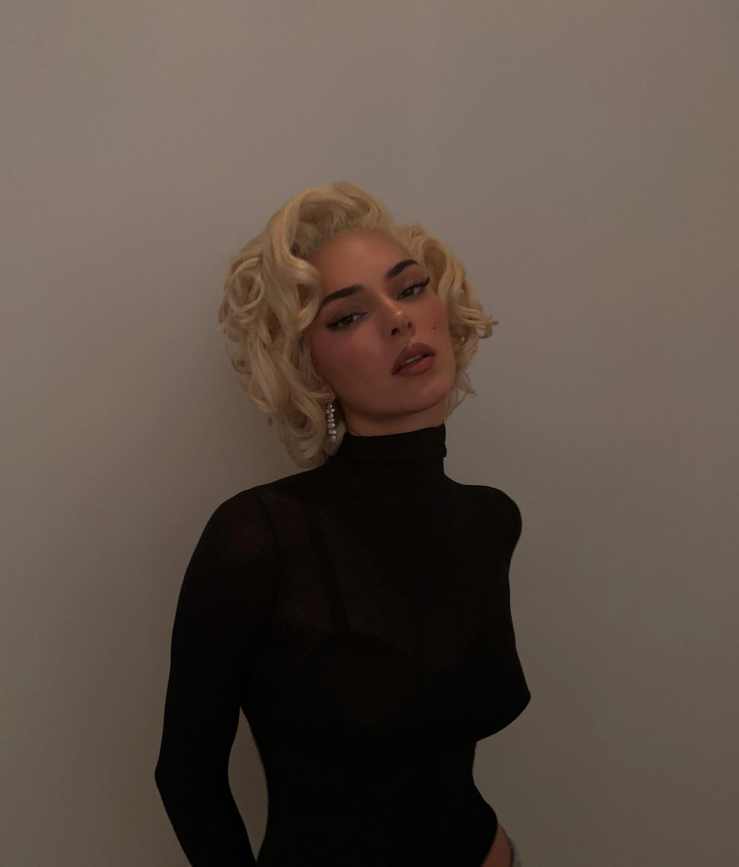Kendall Jenner seen dressed as Marilyn Monroe for Halloween 2023 with a blonde wig, black dress, and pearl earrings