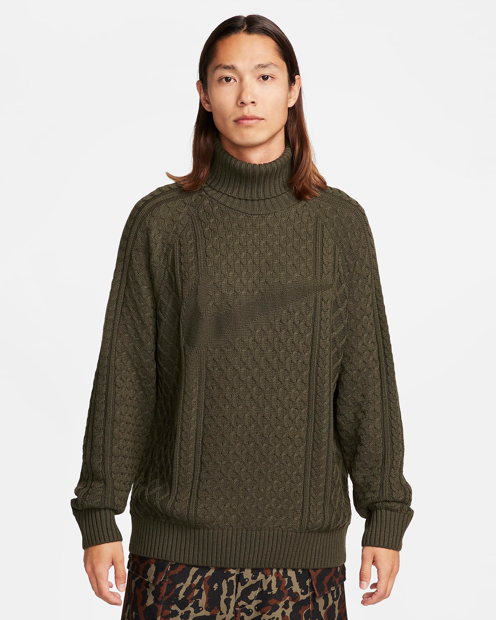 Models wear Nike's cable-knit sweater in white and olive colors