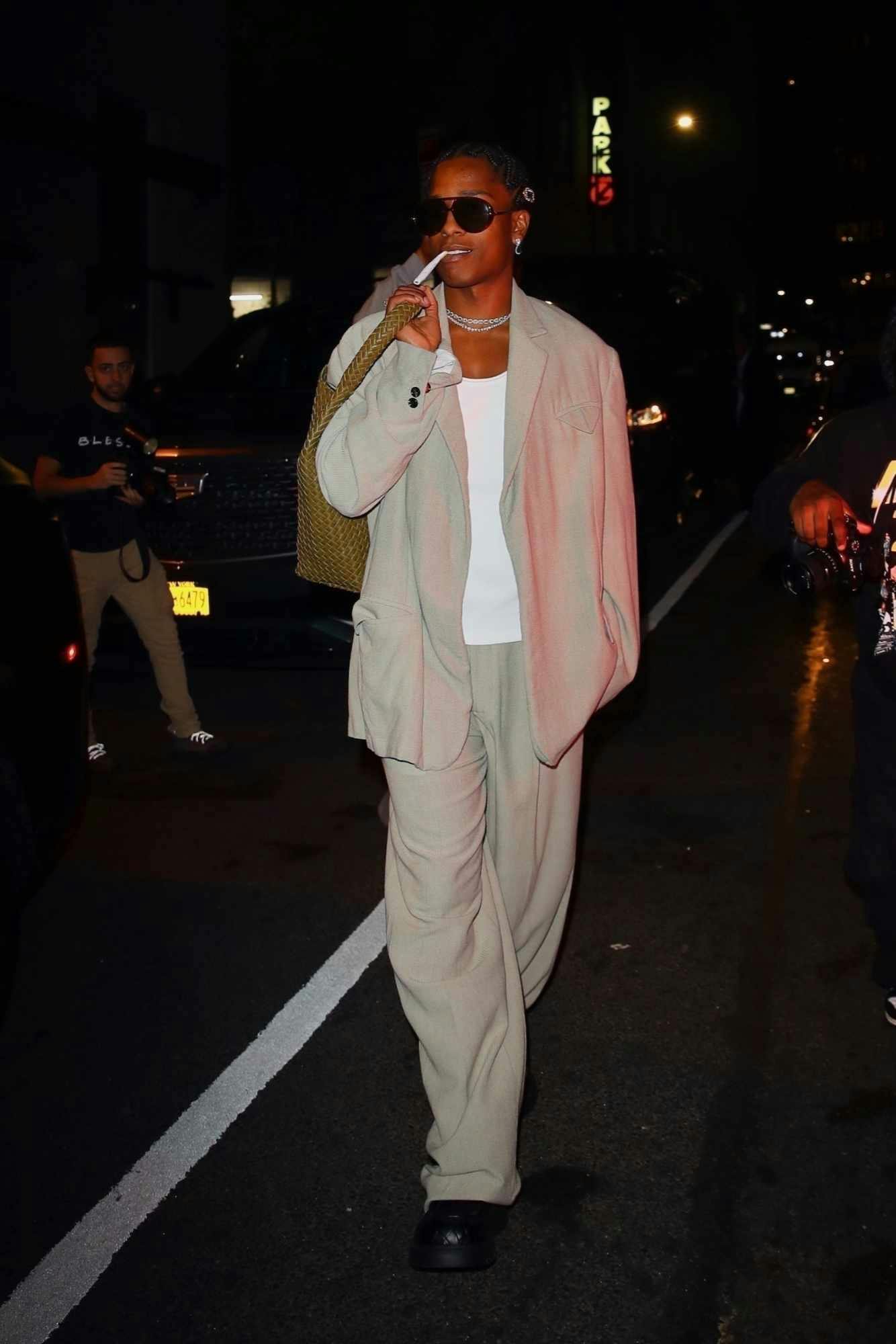 Asap Rocky wears black sunglasses, a leather jacket, Supreme sweatpants, and PUMA sneakers at the Bottega Veneta store in los Angeles