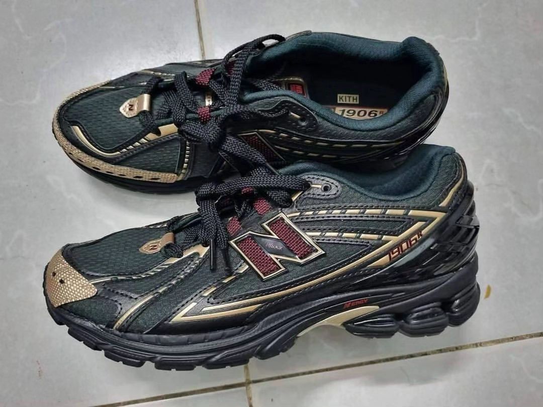 A photograph of KITH's black and gold New Balance 1906 sneaker collab