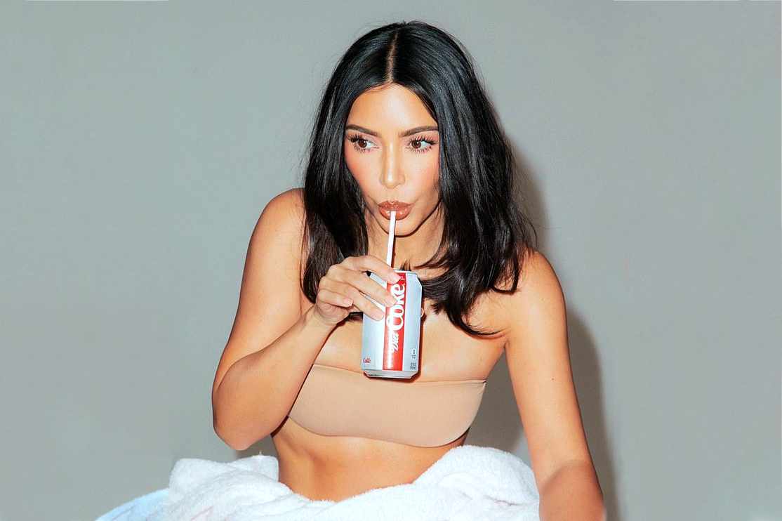 Kim Kardashian drinks a Diet Coke while wearing beige shapewear in a KKW Beauty campaign
